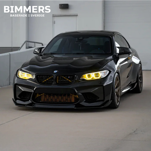 Frontvy av en BMW 2-serie M2 F87 utrustad med Bimmers gula CSL DRL-ljus