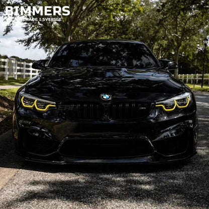 Frontvy av en BMW M4 F82 med tända gula CSL-inspirerade DRL-ljus från Bimmers