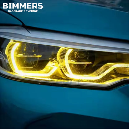 Närbild av en blå BMW F90 med gula DRL ljus