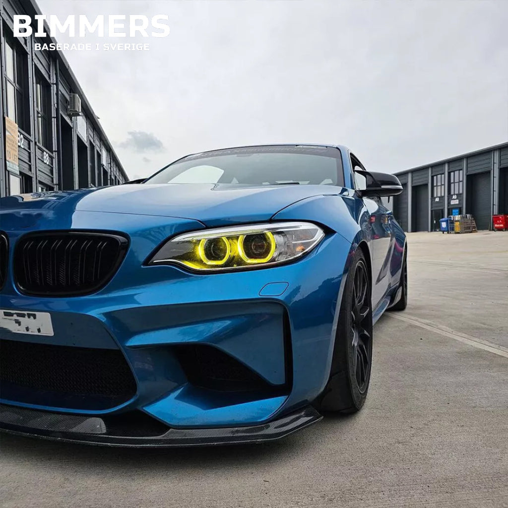Närbild på en tänd BMW F22 strålkastare med gula änglaögon och CSL-look installerat