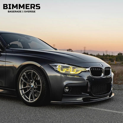 Frontvy av en sänkt BMW F30 med tända gula CSL-inspirerade DRL-ljus