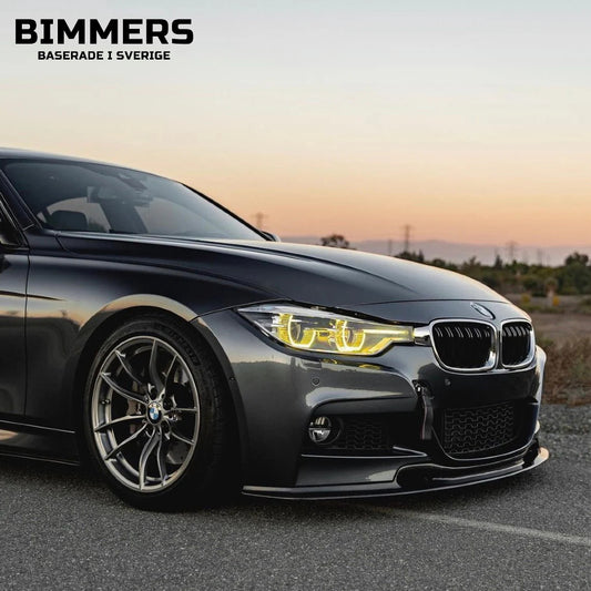 Frontvy av en sänkt BMW F30 med tända gula CSL-inspirerade DRL-ljus