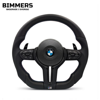En BMW M Sport ratt med flat bottom, svarta plastdetaljer och m-färgade sömmar. Passar flera modeller som exempelvis F30, F31, F10, F11. Original OEM airbag som tillval.