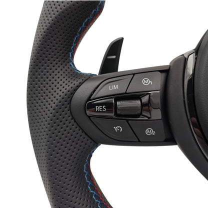 Närbild på multifunktionsknappar för farthållare, M1, M2 på BMW M-Sport flat bottom svart ratt F-serien.