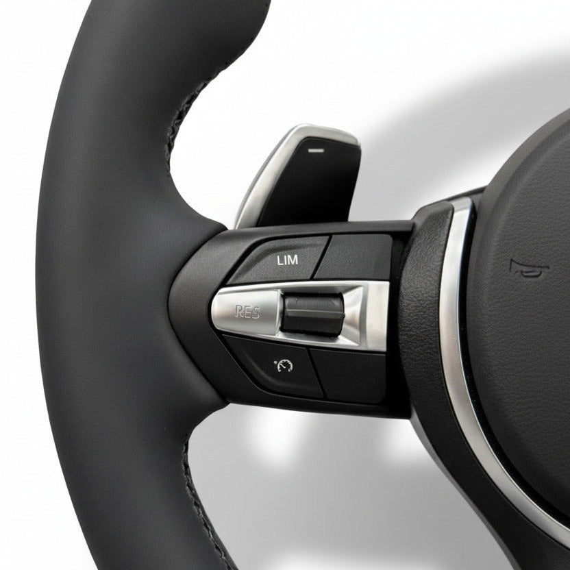 Närbild på multifunktionsknappar för farthållare BMW M-Sport ratt.