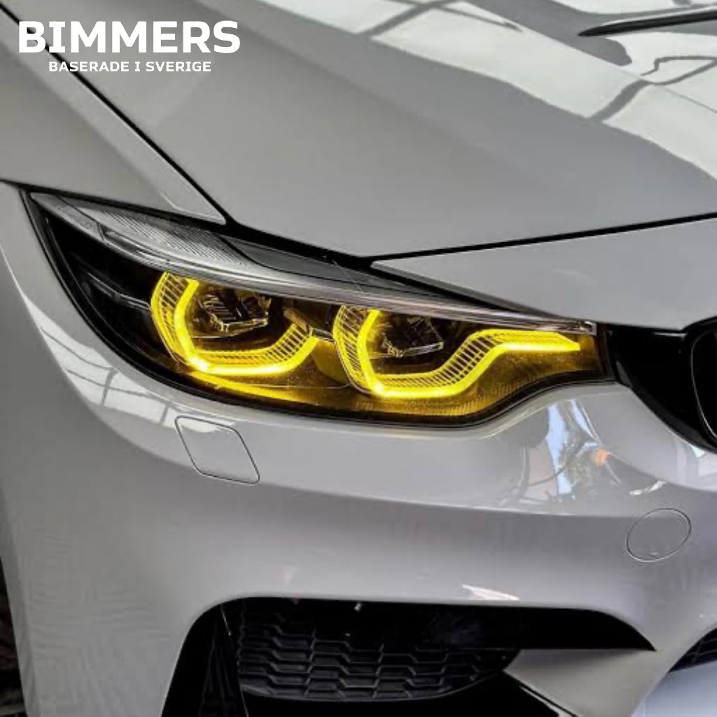 Närbild av gula LED DRL-moduler för BMW 4-serie, M3 och M4 årsmodell 2018-2020 installerade på vit BMW M4